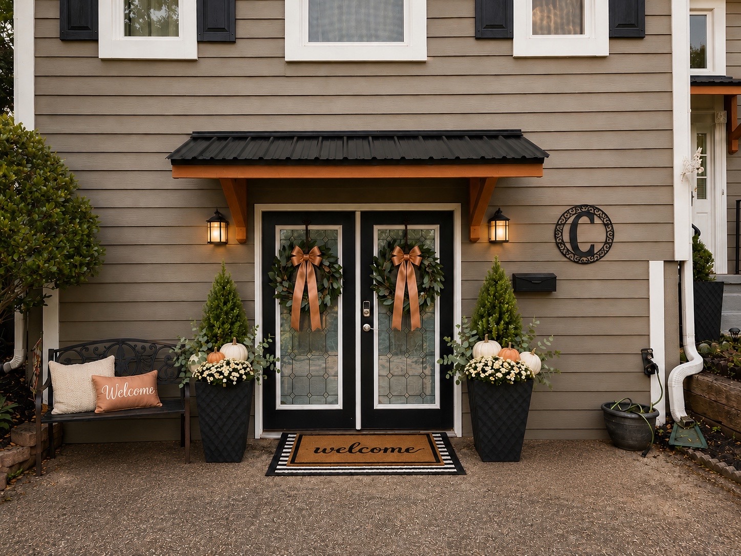 Elegant front porch styled with topiaries, lanterns, and a magnolia wreath